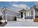 Beautiful gray home showcasing a two-car garage, stylish entryway, and white brick base and accents at 110 Mohave Dr, Louisburg, NC 27549