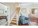 Inviting entryway with wood stairs, blue arm chair, and views into the dining room and living area at 1213 Pierce St, Raleigh, NC 27605