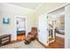 Hallway with wood floors connecting to a bedroom with a bed, and a living area with stairs at 1213 Pierce St, Raleigh, NC 27605