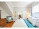 Bedroom featuring hardwood floors, a window, gray chair, and a doorway into another room at 1213 Pierce St, Raleigh, NC 27605