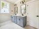 Bathroom with double sink vanity, two mirrors, and white tile floor at 150 Purslane Dr, Franklinton, NC 27525