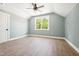 A bedroom with hardwood floors, a ceiling fan, one large window, and an ensuite at 150 Purslane Dr, Franklinton, NC 27525