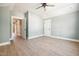 Bright bedroom featuring hardwood floors, a ceiling fan, and two white doors at 150 Purslane Dr, Franklinton, NC 27525
