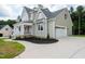 View of the exterior featuring light green siding, a white garage door, and a covered front porch at 150 Purslane Dr, Franklinton, NC 27525