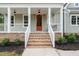 Close-up of the brick stairs and front porch with a orange entry door and white columns at 150 Purslane Dr, Franklinton, NC 27525