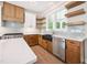 Well-lit kitchen with floating shelves, stainless steel appliances, and blue tile backsplash at 150 Purslane Dr, Franklinton, NC 27525