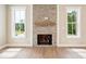 Inviting living room features a brick fireplace, wood mantle, and bright windows at 150 Purslane Dr, Franklinton, NC 27525