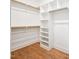 Bright walk-in closet with wood shelving, wooden floor, and white walls at 150 Purslane Dr, Franklinton, NC 27525