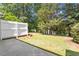 Spacious backyard featuring a lush green lawn and a view of a tranquil lake at 1505 Poets Glade Dr, Apex, NC 27523