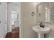 Stylish powder room with pedestal sink and an ornate mirror next to the foyer at 1505 Poets Glade Dr, Apex, NC 27523