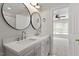 Bathroom with double vanity sink, round mirrors, and bedroom view at 1505 Poets Glade Dr, Apex, NC 27523