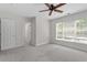 This bedroom offers carpet, neutral walls, one large window and a ceiling fan at 1505 Poets Glade Dr, Apex, NC 27523