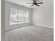 This bedroom offers one large window with blinds, carpet, neutral walls, and a ceiling fan at 1505 Poets Glade Dr, Apex, NC 27523