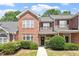 Charming brick townhome with a manicured lawn and a welcoming front door wreath at 1505 Poets Glade Dr, Apex, NC 27523