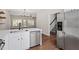 Open concept kitchen with stainless steel refrigerator, modern fixtures, and hardwood floors at 1505 Poets Glade Dr, Apex, NC 27523