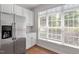 Bright kitchen nook area features stainless steel refrigerator and natural light at 1505 Poets Glade Dr, Apex, NC 27523