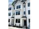 Modern townhome exteriors featuring white siding, black framed windows, and contemporary design elements at 1531 Crescent Townes Way, Raleigh, NC 27604