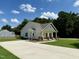 View of the home's exterior showcasing a long driveway and a well-maintained lawn at 172 W Old Rd, Lillington, NC 27546