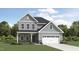 Charming two-story home with gray siding, a covered porch, and an attached two-car garage at 1732 Goldfinch Perch Ln, Knightdale, NC 27545