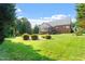 Lush green backyard featuring a sunroom with a screened-in porch, offering a peaceful outdoor space at 175 Georgetown Woods Dr, Youngsville, NC 27596