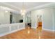 Open dining room with chandelier, hardwood flooring, and open access to kitchen and living room at 175 Georgetown Woods Dr, Youngsville, NC 27596