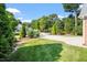 Expansive front yard with a long driveway leading to a beautiful brick home and lush trees at 175 Georgetown Woods Dr, Youngsville, NC 27596