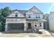 Exterior elevation of an unfinished two-story home with a two-car garage and covered porch at 177 Millwood Dr, Clayton, NC 27527