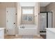 Bright bathroom featuring a soaking tub under a window and a glass-enclosed shower at 20 Kola Nut, Smithfield, NC 27577