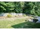 Beautifully landscaped backyard featuring a stone retaining wall, manicured lawn, and privacy fence at 212 Mickleson Ridge Dr, Raleigh, NC 27603