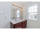 Bright bathroom featuring double sinks, and a vanity with a large mirror and decorative lighting at 212 Mickleson Ridge Dr, Raleigh, NC 27603