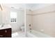 Bright bathroom featuring double sinks, tiled floors, and a bathtub with tiled surround at 212 Mickleson Ridge Dr, Raleigh, NC 27603