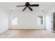 Empty bedroom showcasing neutral walls, carpet, a ceiling fan, and natural light from two windows at 212 Mickleson Ridge Dr, Raleigh, NC 27603