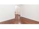 An empty room with hardwood flooring and an arched entryway providing versatility for living space customization at 212 Mickleson Ridge Dr, Raleigh, NC 27603