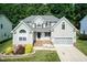 Traditional two-story home with a manicured lawn, gray siding, and a two-car garage at 212 Mickleson Ridge Dr, Raleigh, NC 27603