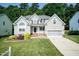 Charming two-story home with a well-manicured lawn, garden, and an attached two-car garage at 212 Mickleson Ridge Dr, Raleigh, NC 27603