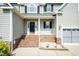 Inviting front porch with brick steps and white railing, complemented by a well-maintained lawn at 212 Mickleson Ridge Dr, Raleigh, NC 27603