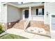 Inviting front porch with brick steps and white railing, complemented by a well-maintained lawn at 212 Mickleson Ridge Dr, Raleigh, NC 27603