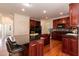 An open kitchen with cherry wood cabinetry and black countertop space offering a rich, functional design at 212 Mickleson Ridge Dr, Raleigh, NC 27603