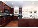 Well-equipped kitchen featuring dark wood cabinets, granite countertops, and stainless steel appliances at 212 Mickleson Ridge Dr, Raleigh, NC 27603