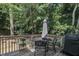 Relaxing back deck featuring a table, chairs, an umbrella and a grill surrounded by lush greenery at 213 N Weststone Blvd, Fuquay Varina, NC 27526