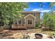 The backyard shows a deck with an outdoor grill on a stone patio with seating and mature trees at 213 N Weststone Blvd, Fuquay Varina, NC 27526