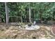 Backyard features a stone patio, seating area, and a swing set surrounded by mature trees at 213 N Weststone Blvd, Fuquay Varina, NC 27526