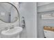 Stylish half-bathroom featuring modern fixtures and a round mirror at 213 N Weststone Blvd, Fuquay Varina, NC 27526