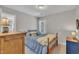 Cozy bedroom with a wood-framed bed, complemented by natural light from the window at 213 N Weststone Blvd, Fuquay Varina, NC 27526