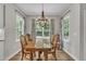 Inviting dining room with a wooden table, chandelier, and natural light from multiple windows at 213 N Weststone Blvd, Fuquay Varina, NC 27526