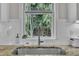 Close-up showcasing the kitchen sink area, with a stainless steel faucet and a window view of the backyard at 213 N Weststone Blvd, Fuquay Varina, NC 27526