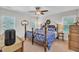 Primary bedroom with a four-poster bed, ceiling fan, and ample natural light, exuding elegance at 213 N Weststone Blvd, Fuquay Varina, NC 27526