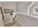 Carpeted staircase with a round window and neutral walls at 213 N Weststone Blvd, Fuquay Varina, NC 27526