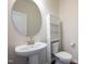 A well-lit powder room with modern fixtures, white vanity, and a round mirror at 217 Windy Knoll Dr, Graham, NC 27253