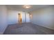 A simple bedroom featuring neutral carpet and walls, and a large window for natural light at 217 Windy Knoll Dr, Graham, NC 27253